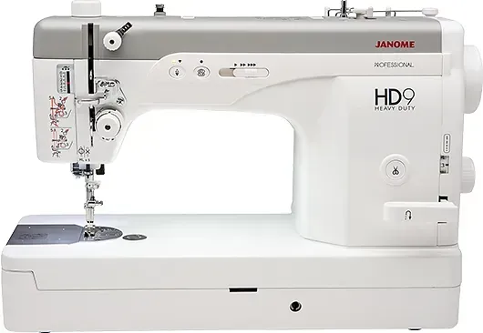 Una máquina de coser blanca está sobre una mesa blanca.