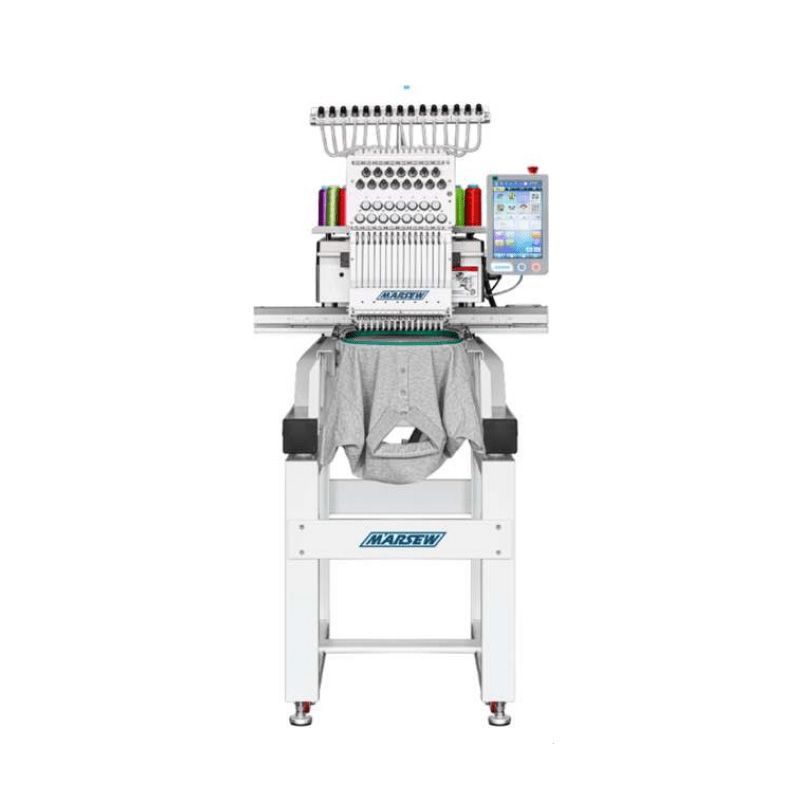 Máquina de bordar blanca cosiendo una sudadera gris, con un pequeño panel de control táctil y carretes de hilo.