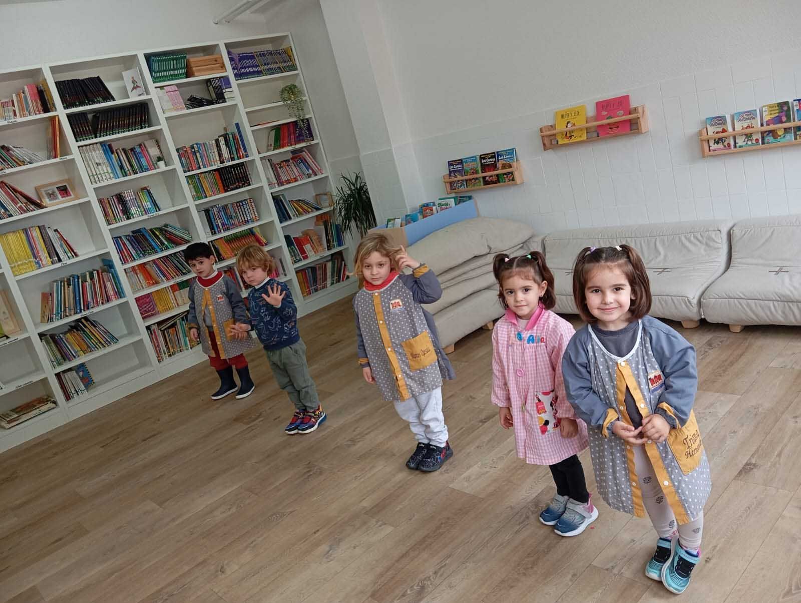 Un grupo de niños está de pie en una habitación con estanterías.