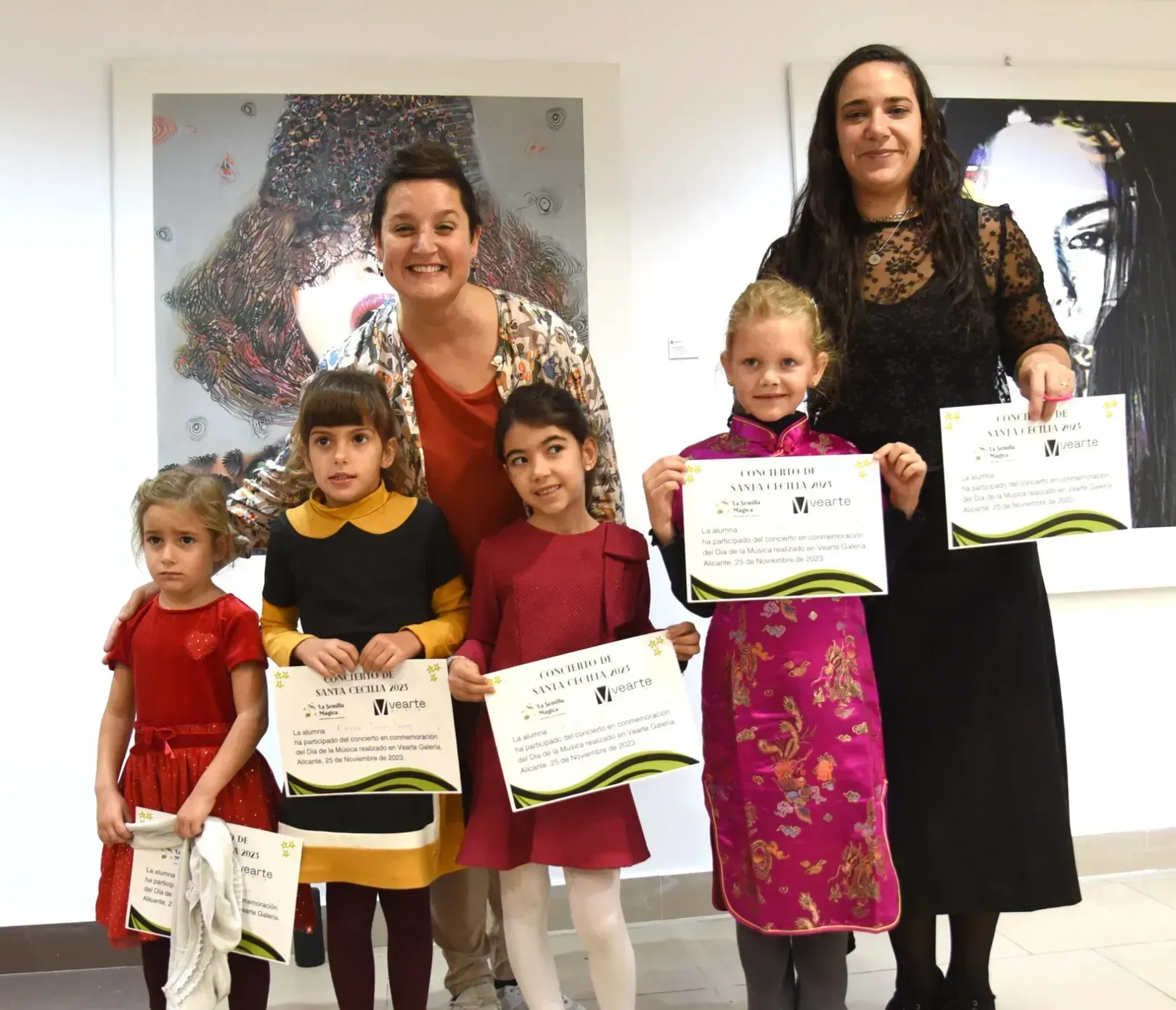 Un grupo de mujeres y niños sostienen certificados.