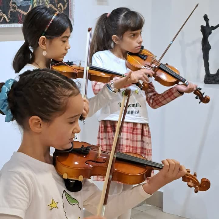 Una niña tocando un violín con una camiseta que dice magia.