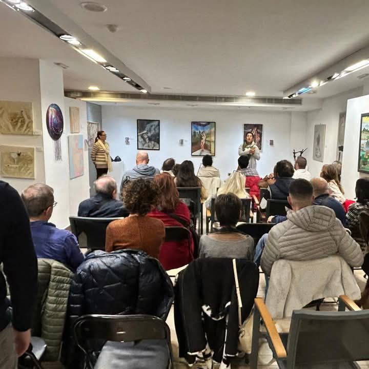 Un grupo de personas están sentadas en sillas en una habitación.
