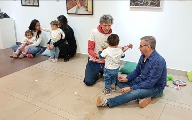 Un grupo de personas está jugando con niños en una habitación.