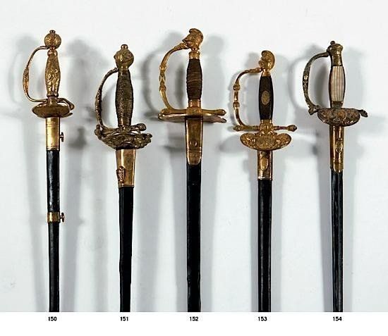 Cinq épées de collection, ornées de poignées dorées et de poignées noires, présentées en rangée.