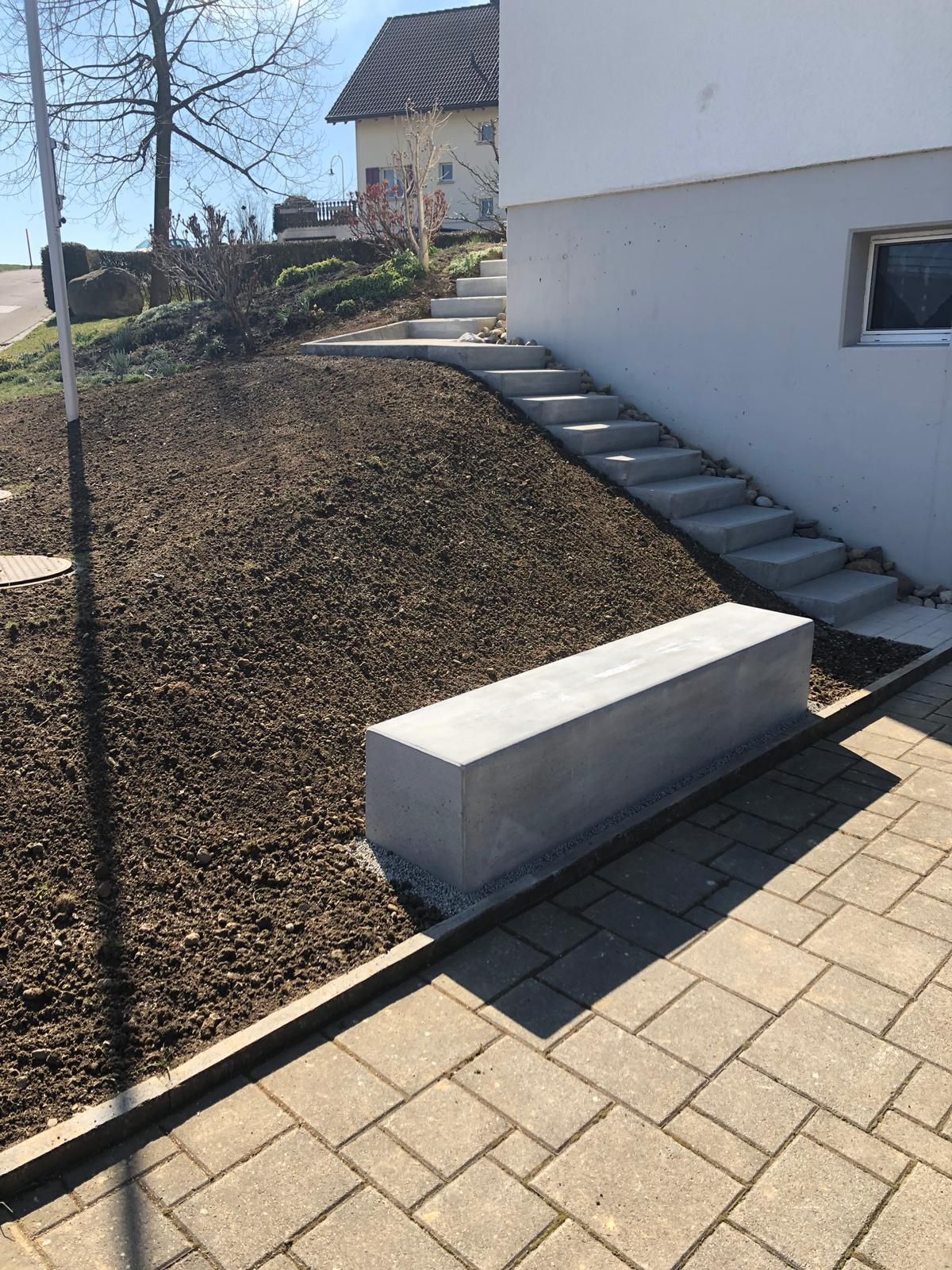 Gehweg neben Bord mit frisch gesätem Rasen