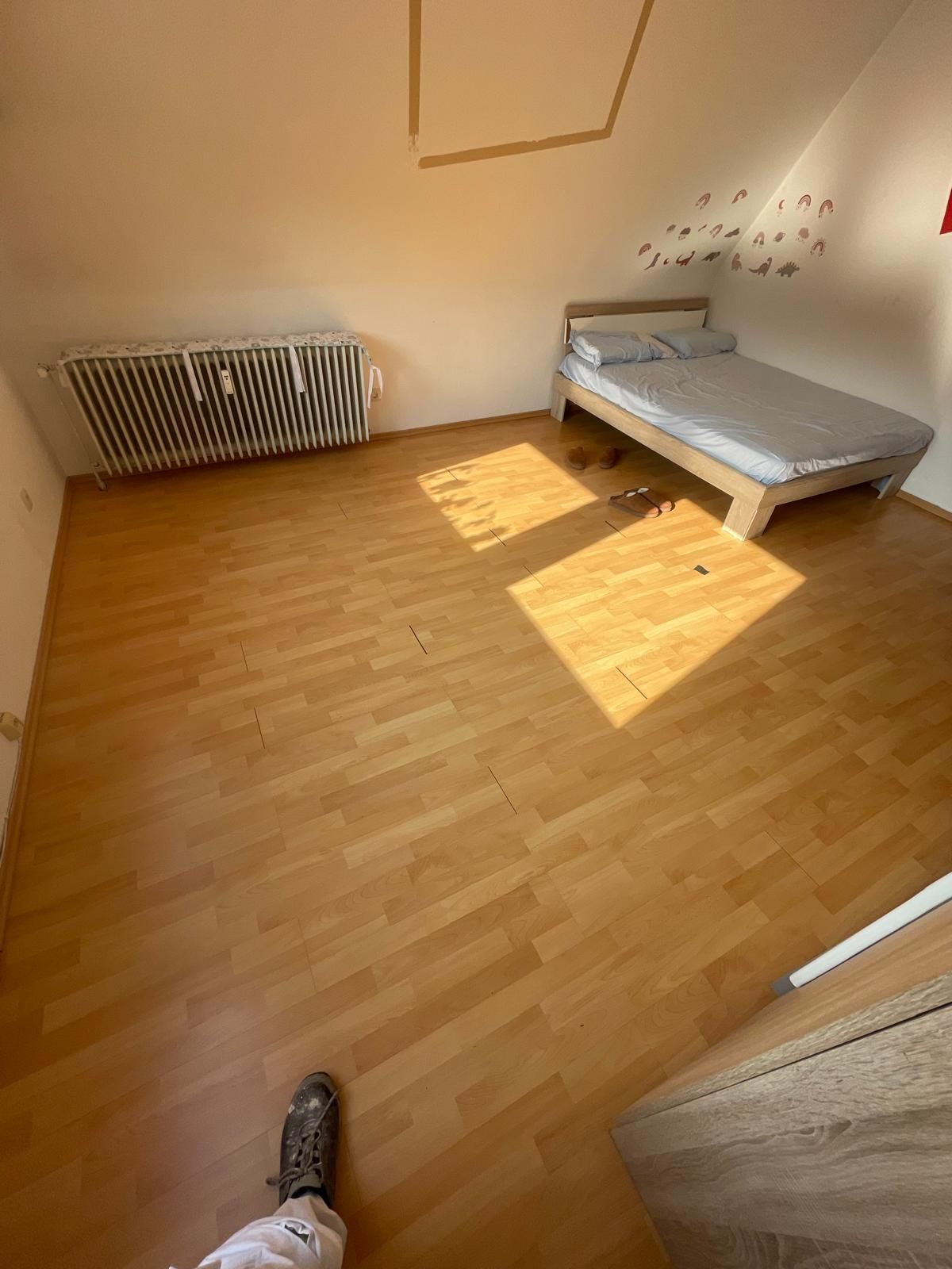 Ein Schlafzimmer mit Holzboden und einem Bett.