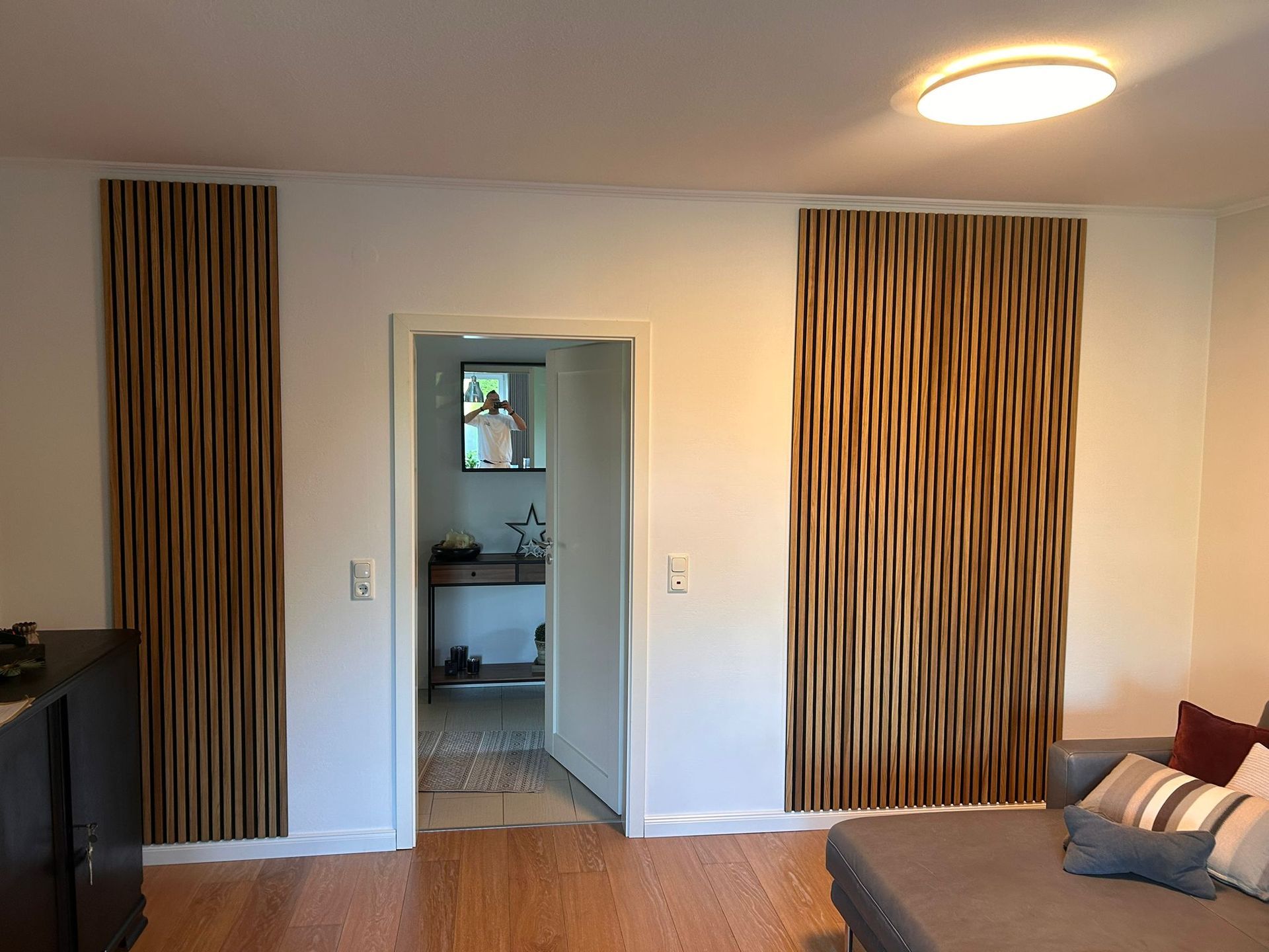 Ein Wohnzimmer mit einem Sofa und einer Tür, die zu einem Badezimmer führt.