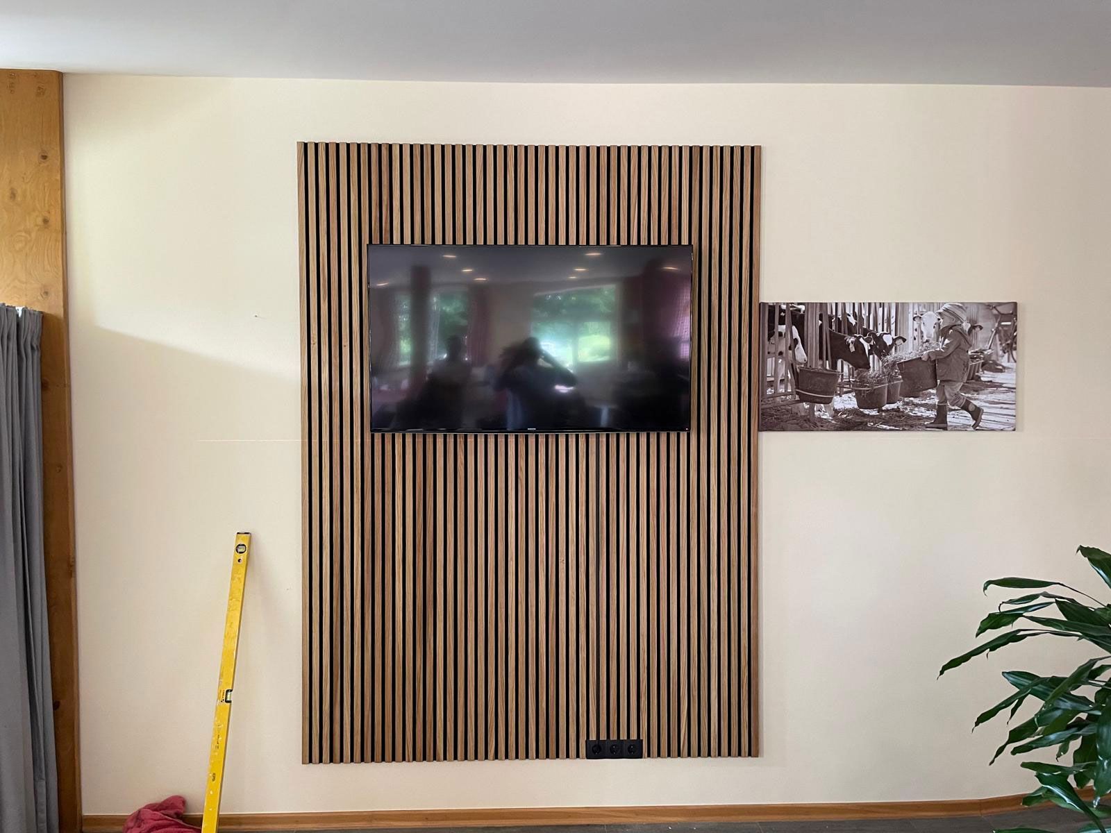 Ein Fernseher ist an der Wand in einem Wohnzimmer montiert.