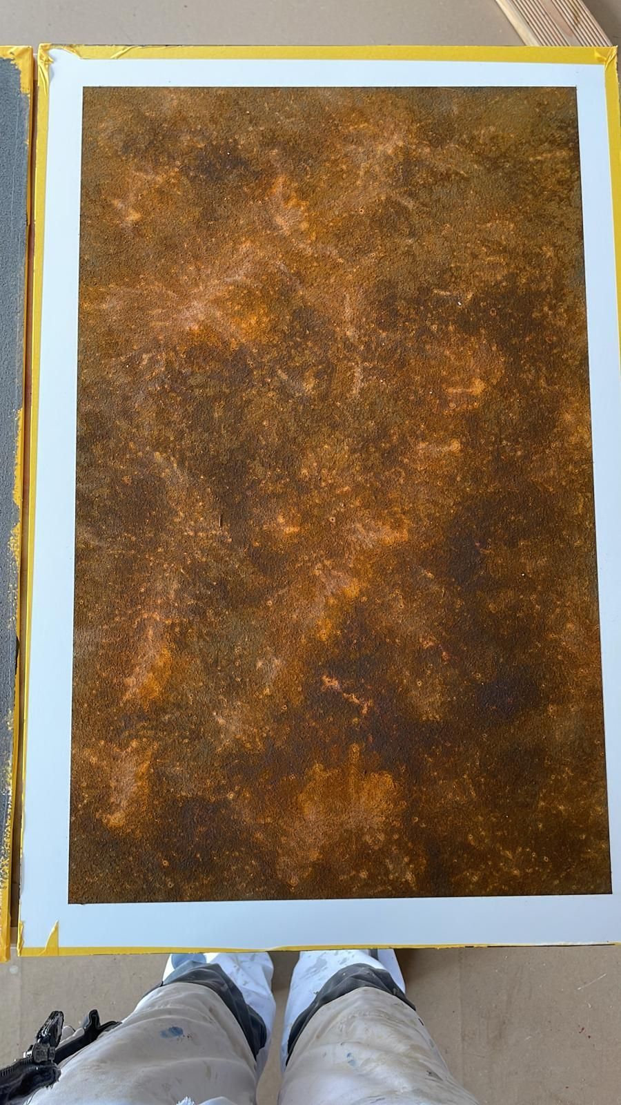 Eine Person steht neben einem Stück braunem Papier.