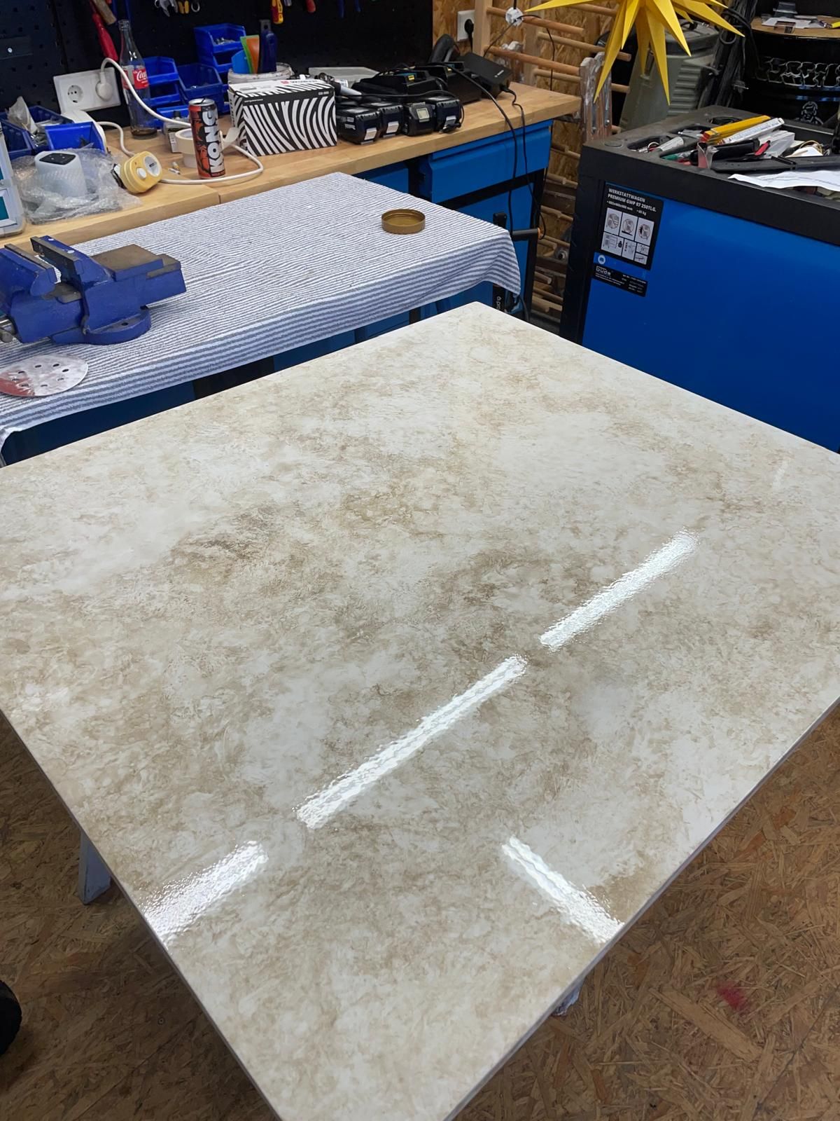 In einer Werkstatt steht ein großer Marmortisch auf einem Holztisch.