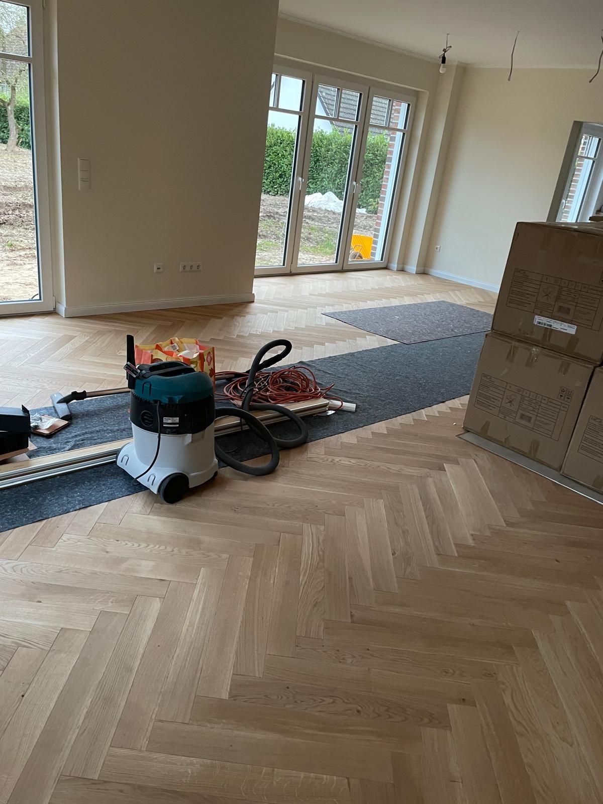 Ein Staubsauger steht auf einem Holzboden in einem Zimmer.