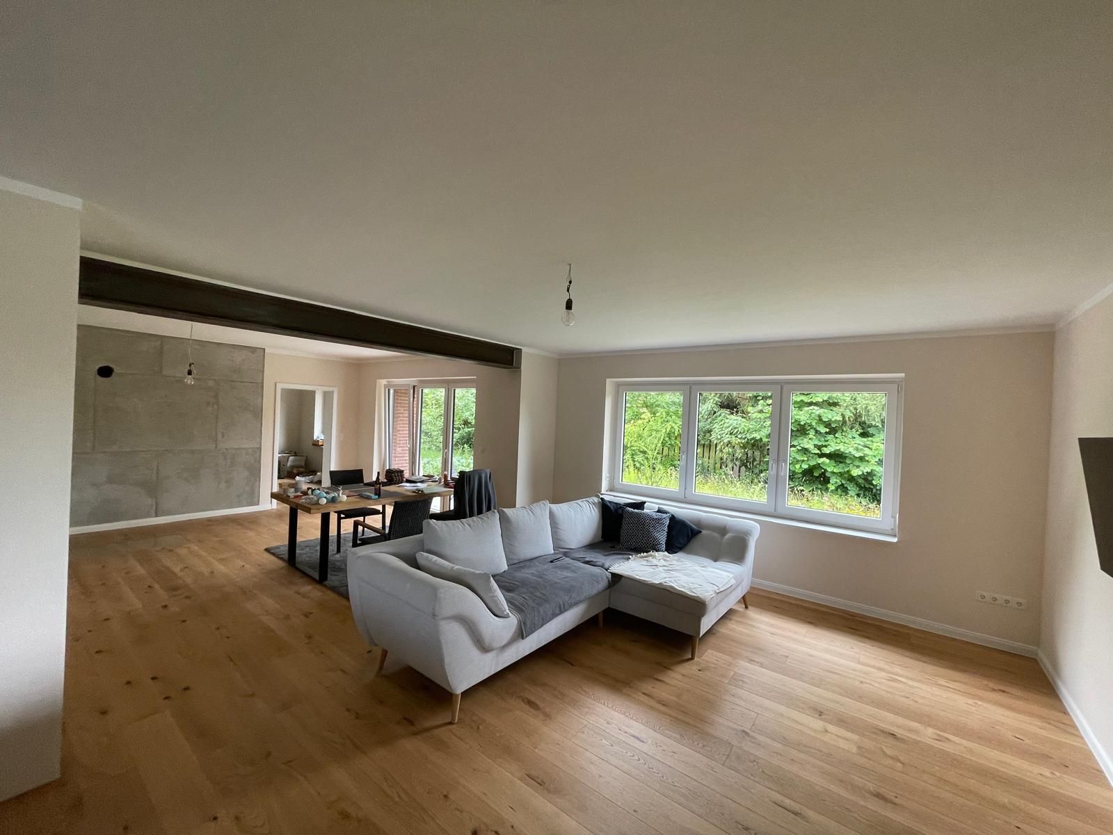 Ein Wohnzimmer mit einem weißen Sofa und Holzböden.