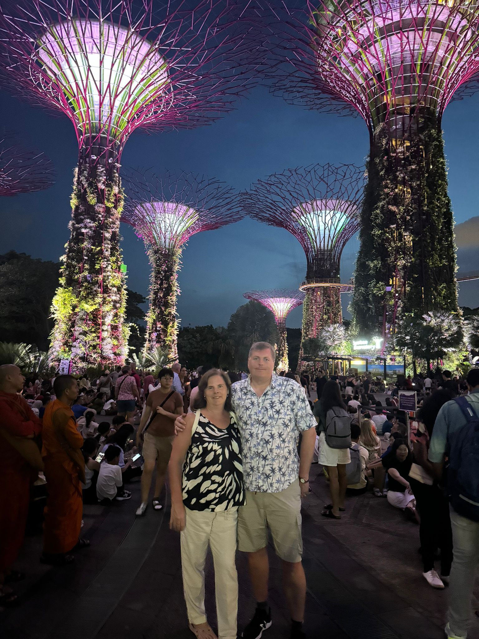 A man and a woman are posing for a picture in front of a crowd of people.S