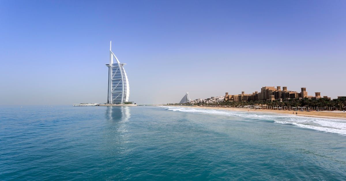 A large building is sitting on top of a small island in the middle of the ocean.