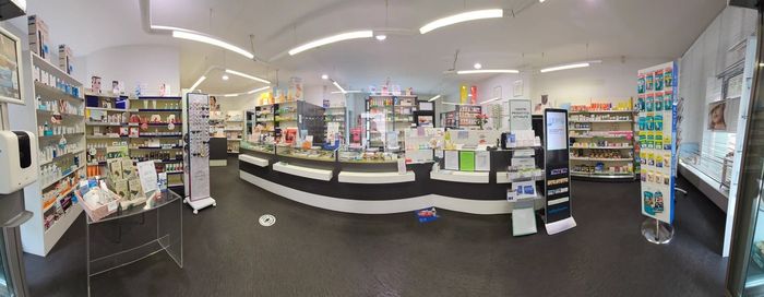 Una vista panoramica di una farmacia con molti scaffali e un bancone.