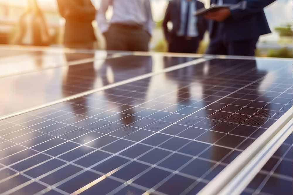 Eine Gruppe von Menschen steht um ein Solarpanel herum.