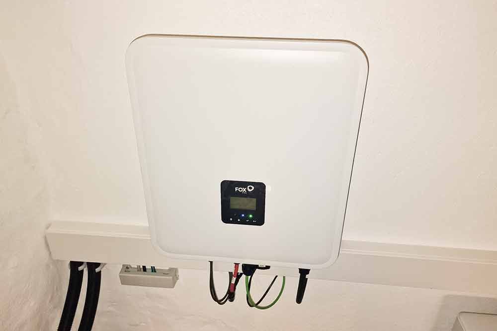 An einer Wand hängt eine weiße Box mit einem Display.