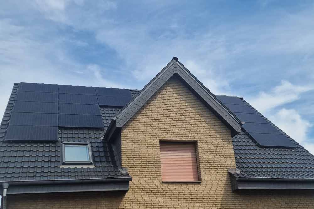 Ein Backsteinhaus mit schwarzen Solarmodulen auf dem Dach
