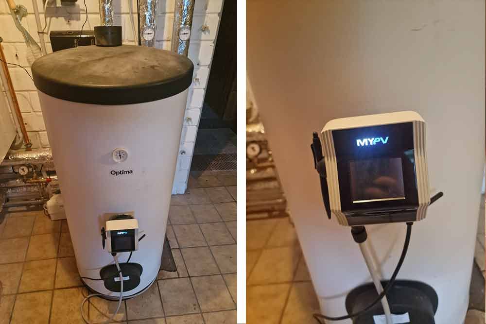 Ein weißer Warmwasserbereiter steht auf einem gefliesten Boden neben einer Wand.