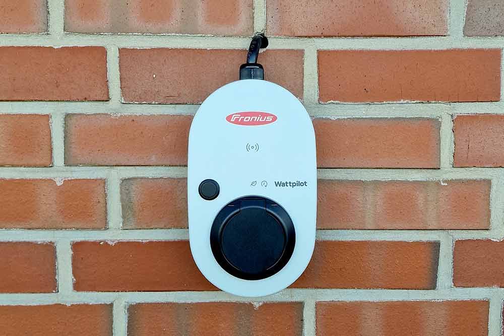 An einer Ziegelwand hängt ein weißes Gerät.