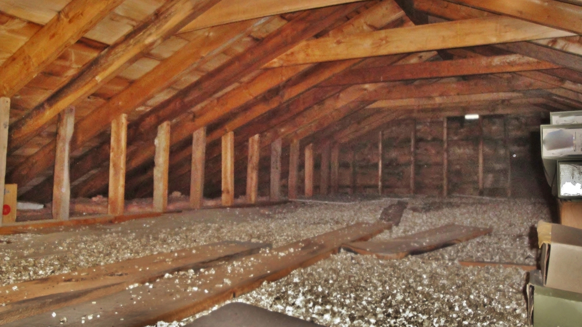 Intérieur du grenier avec poutres, poteaux et isolation en bois.