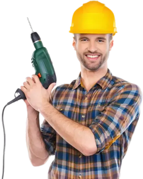 Un homme portant un casque de sécurité tient une perceuse.