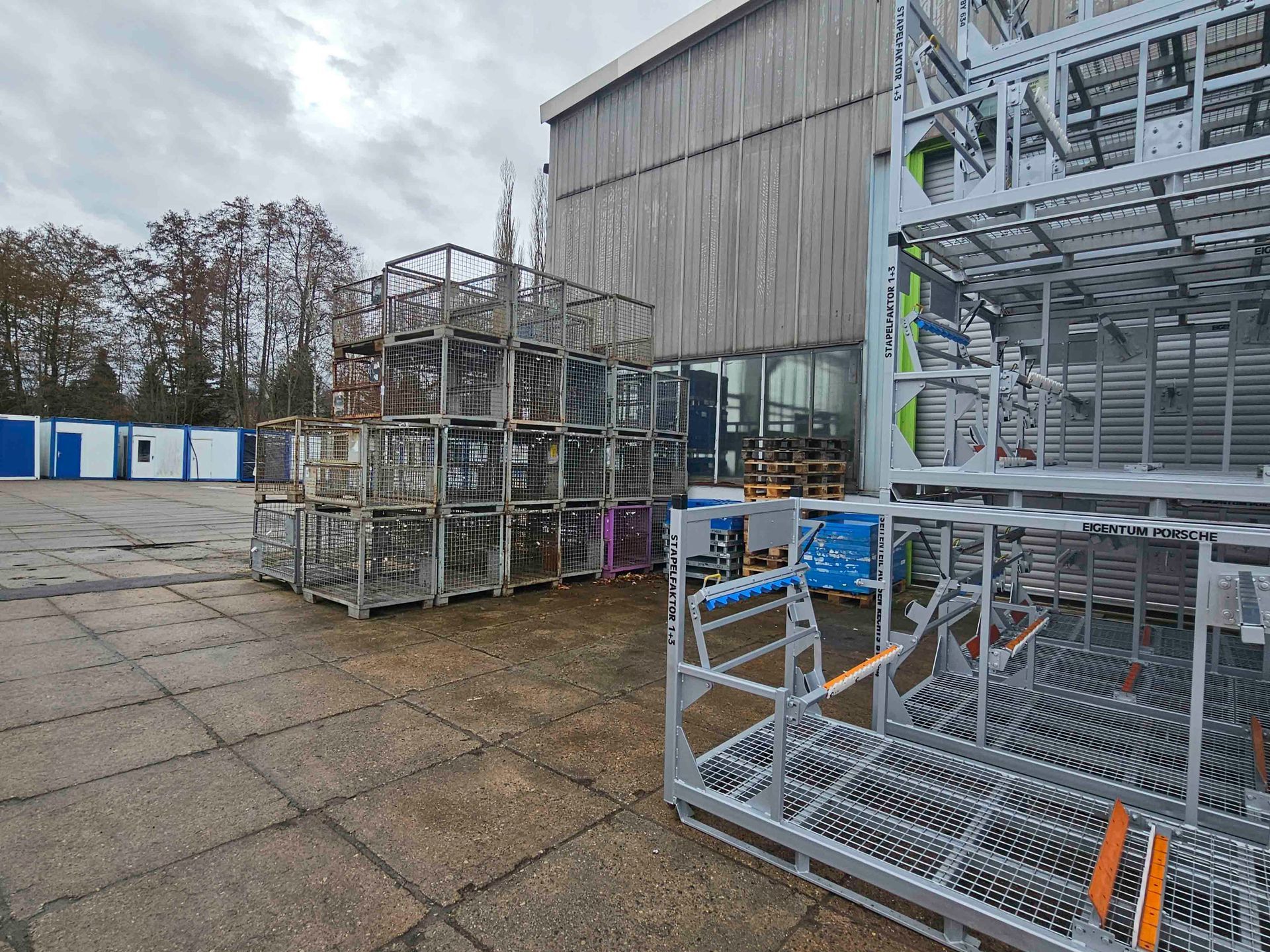 Vor einem Gebäude steht ein Haufen Metallkisten.