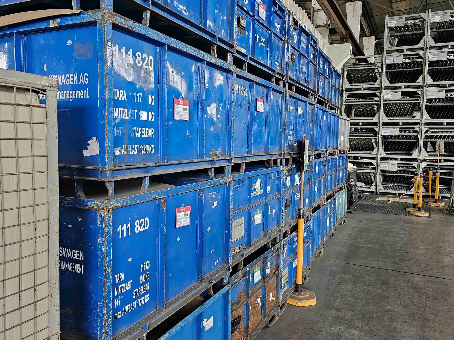 Ein Lagerhaus voller übereinander gestapelter blauer Container.