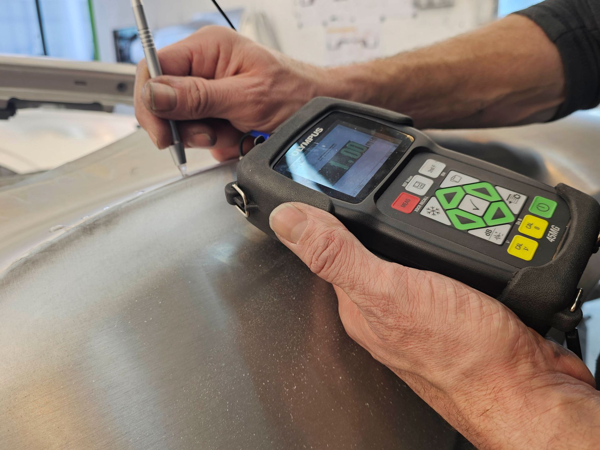 Eine Person hält ein Gerät in den Händen und schreibt darauf.