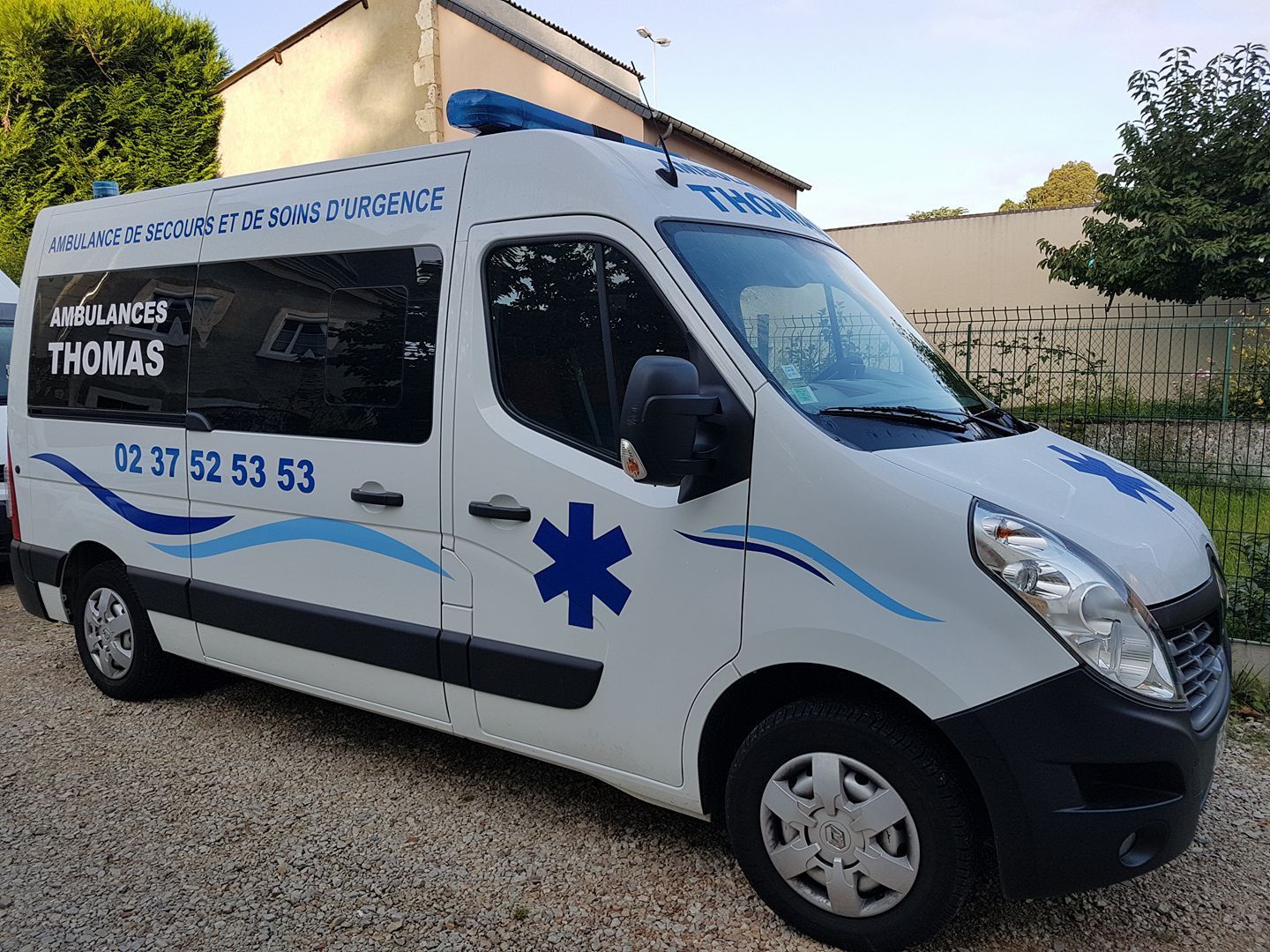 Une ambulance des Ambulances Thomas garée sur une allée en gravillons