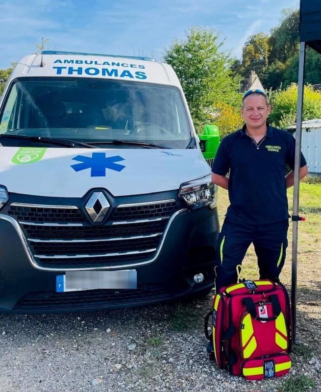 Homme posant à côté d'un véhicule des Ambulances Thomas