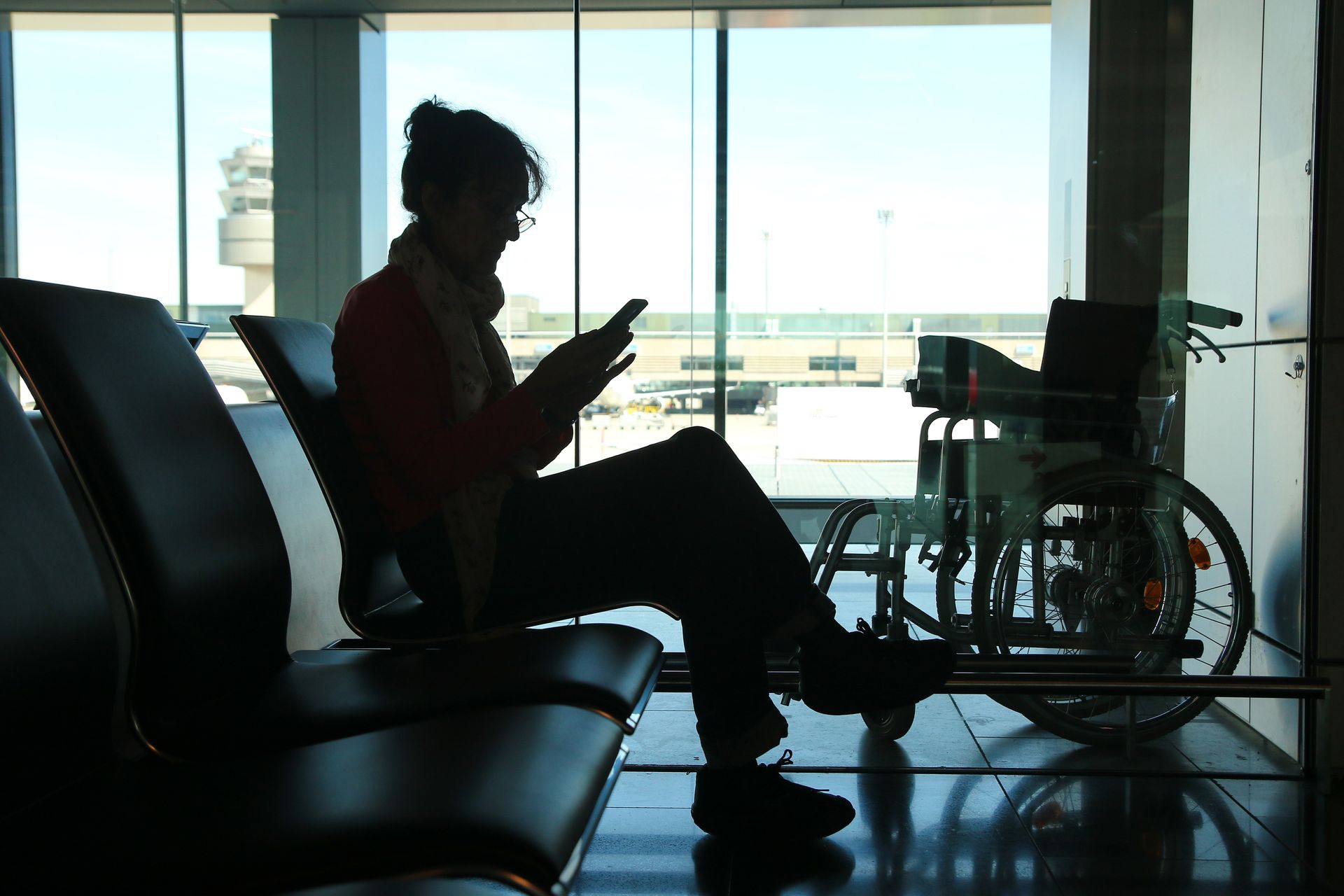 Silhouette d'une femme assise dans l'ombre dans un aéroport