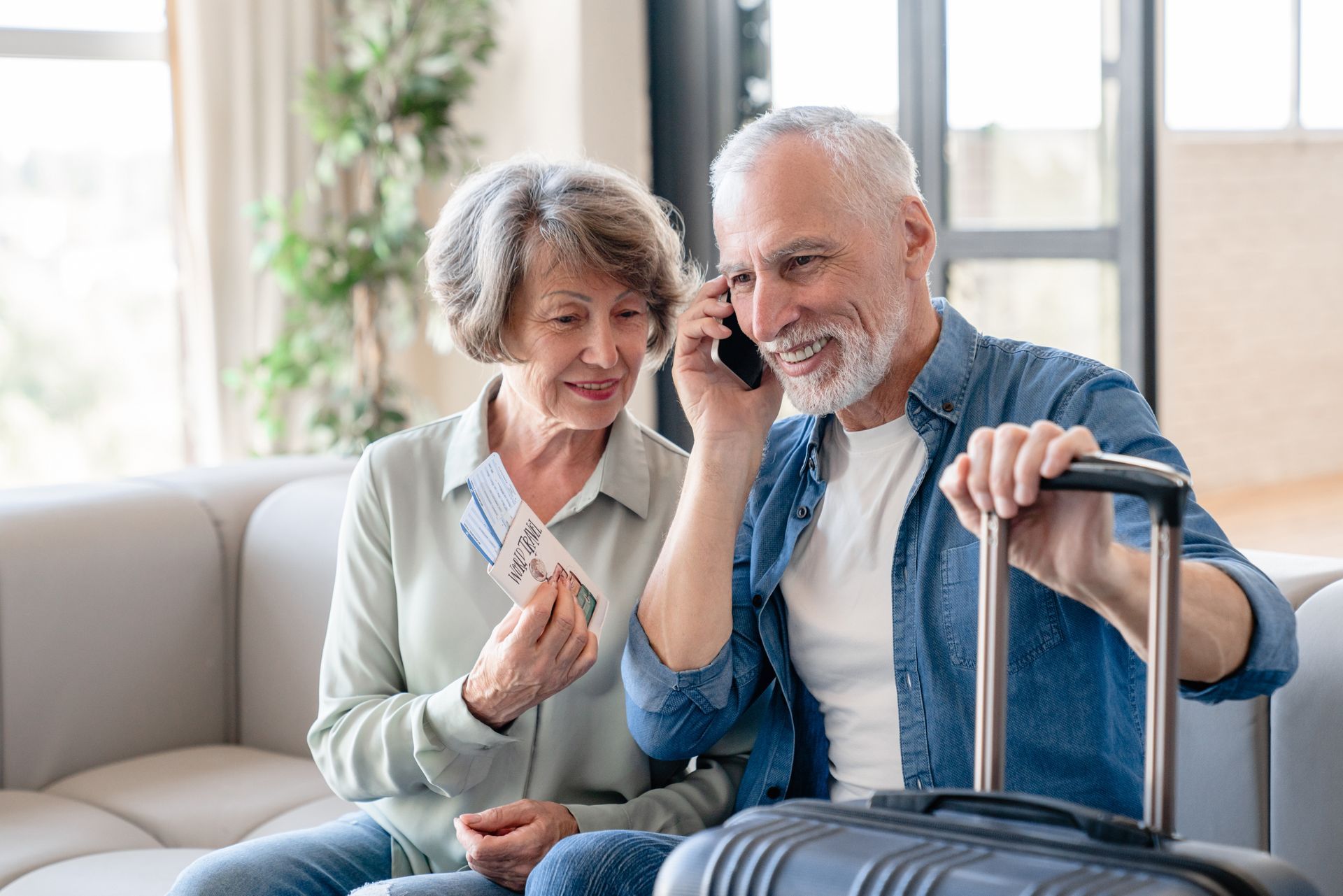 Couple de personnes âgées avec des billets d'avion en main appelant au téléphone