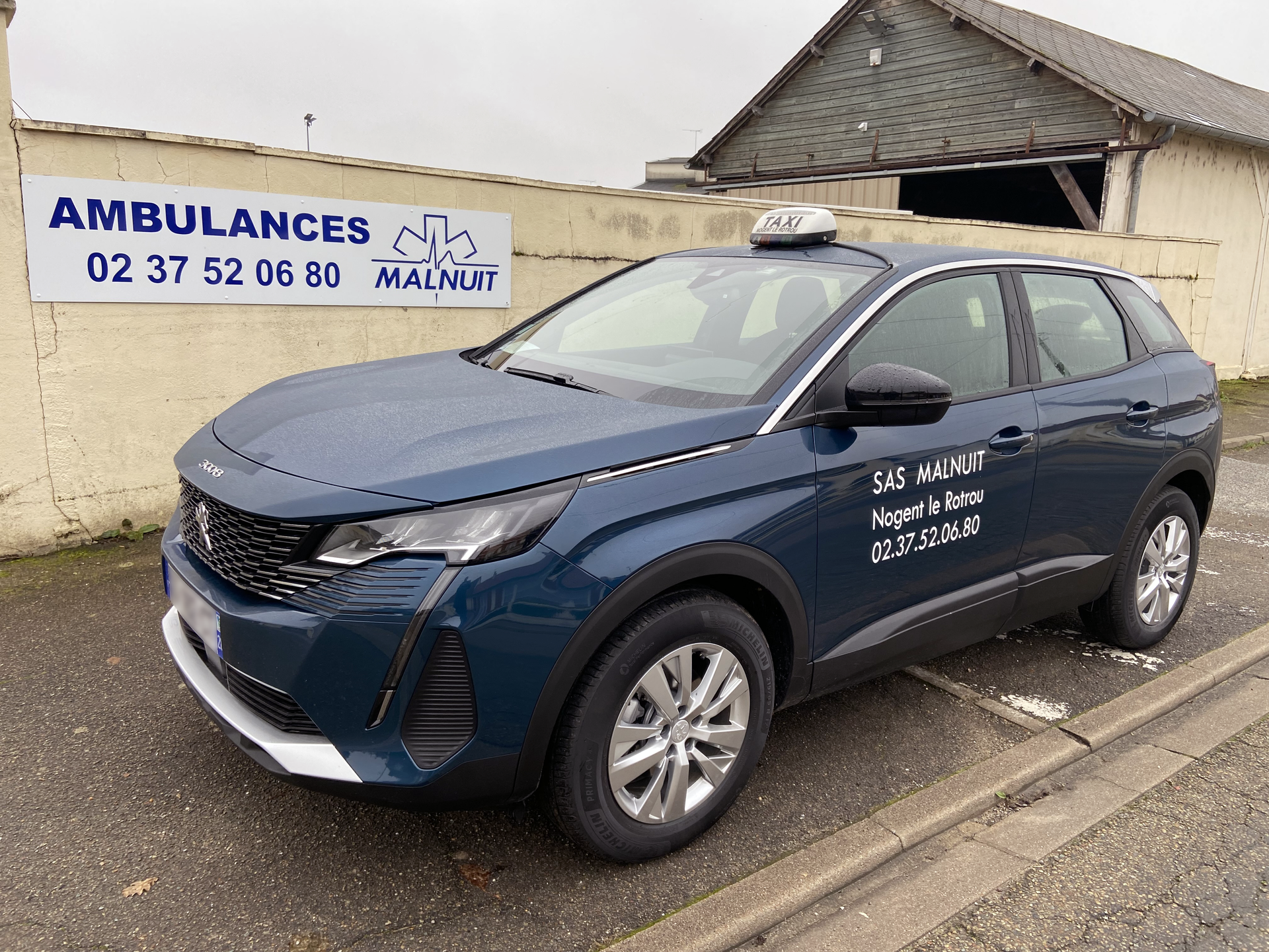 Taxi bleu nuit de l'entreprise Malnuit garé sur le trottoir