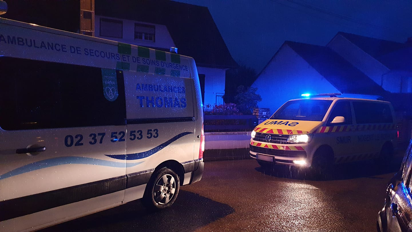 Deux ambulances de nuit aux gyrophares allumés sous la pluie