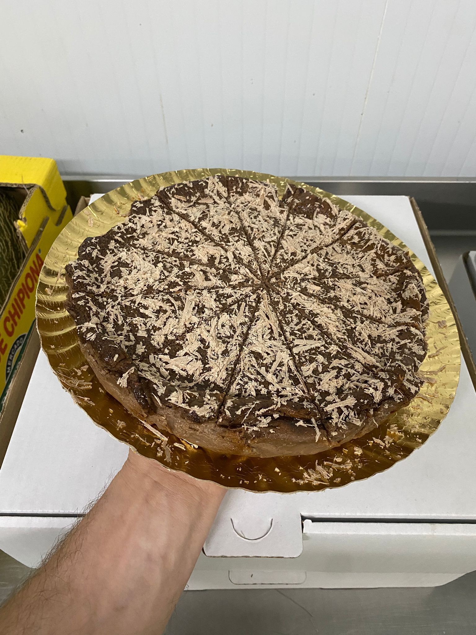 Una persona sostiene una pizza en un plato de papel.