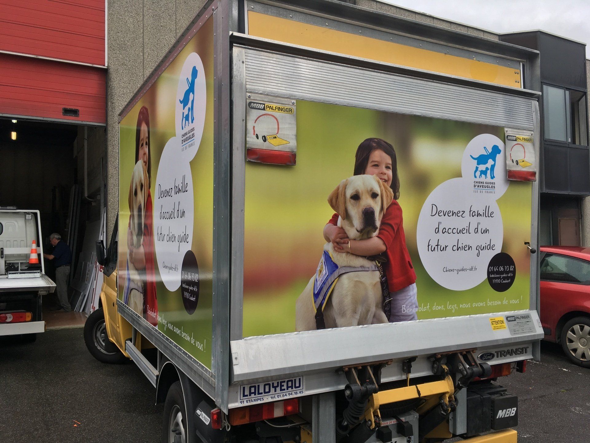 Camion floqué avec une jeune fille et un chien.