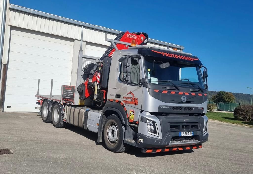 Photo d'un camion gris devant un bâtiment