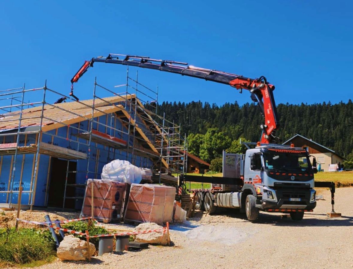 Photo d'une maison en travaux avec des échafaudages et un camion