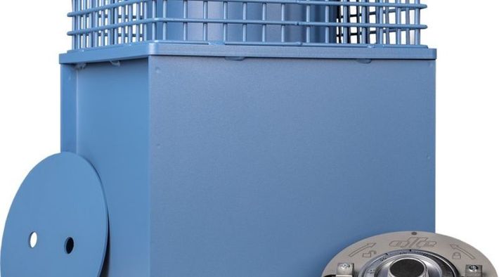 Maquinaria industrial de color azul con una parte superior en forma de jaula, un disco lateral y una parte metálica sobre un fondo blanco.