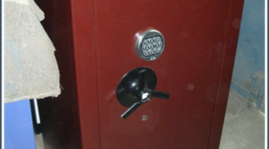 Caja fuerte metálica de color rojo con teclado digital y tirador.