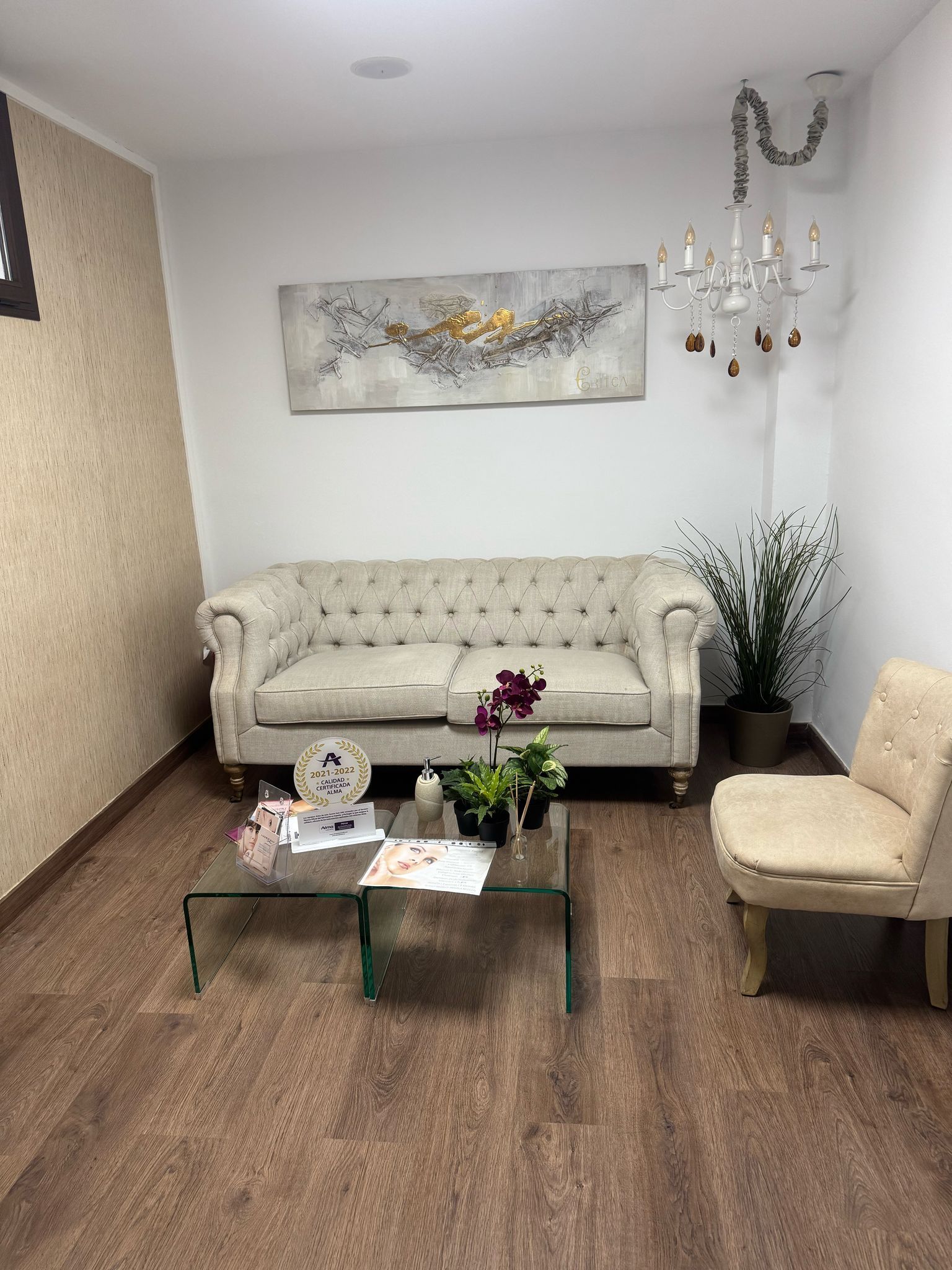 Una sala de estar con un sofá, una silla, una mesa de café y una lámpara de araña.