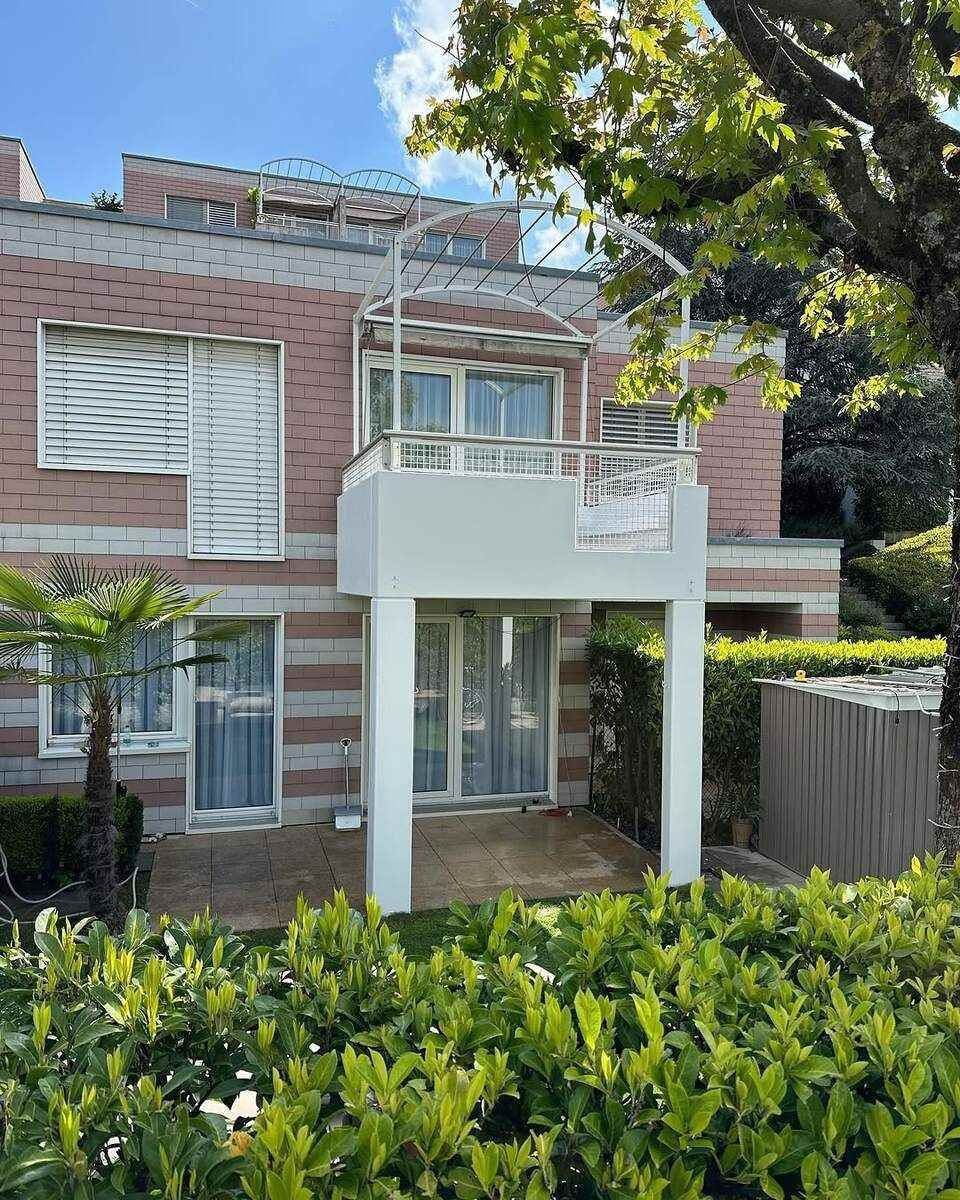 Villa de deux étages en briques avec balcon.