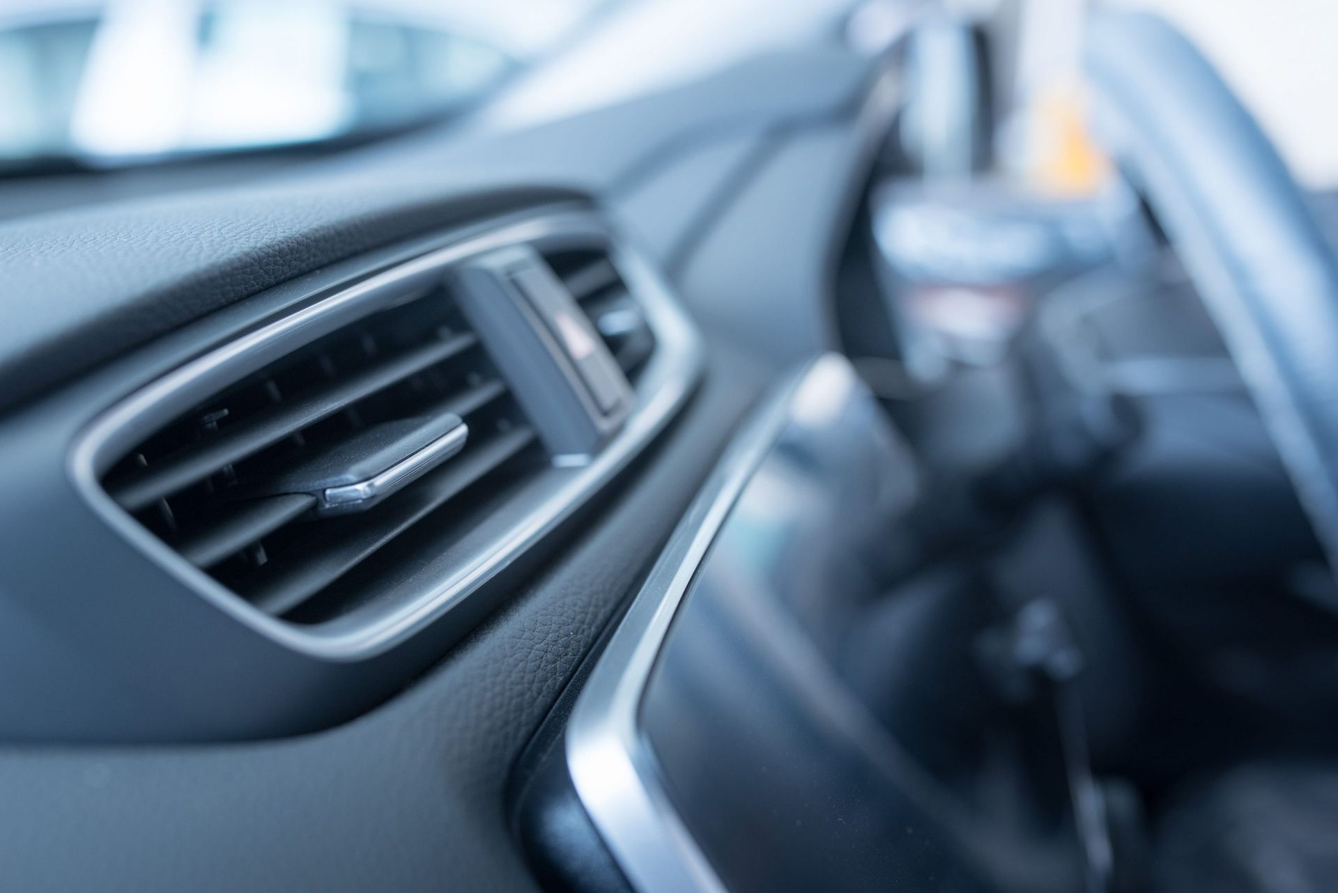 Eine Nahaufnahme der Lüftungsschlitze auf dem Armaturenbrett eines Autos.