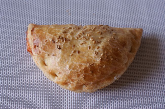 Sobre una mesa hay un pastel con semillas de sésamo encima.