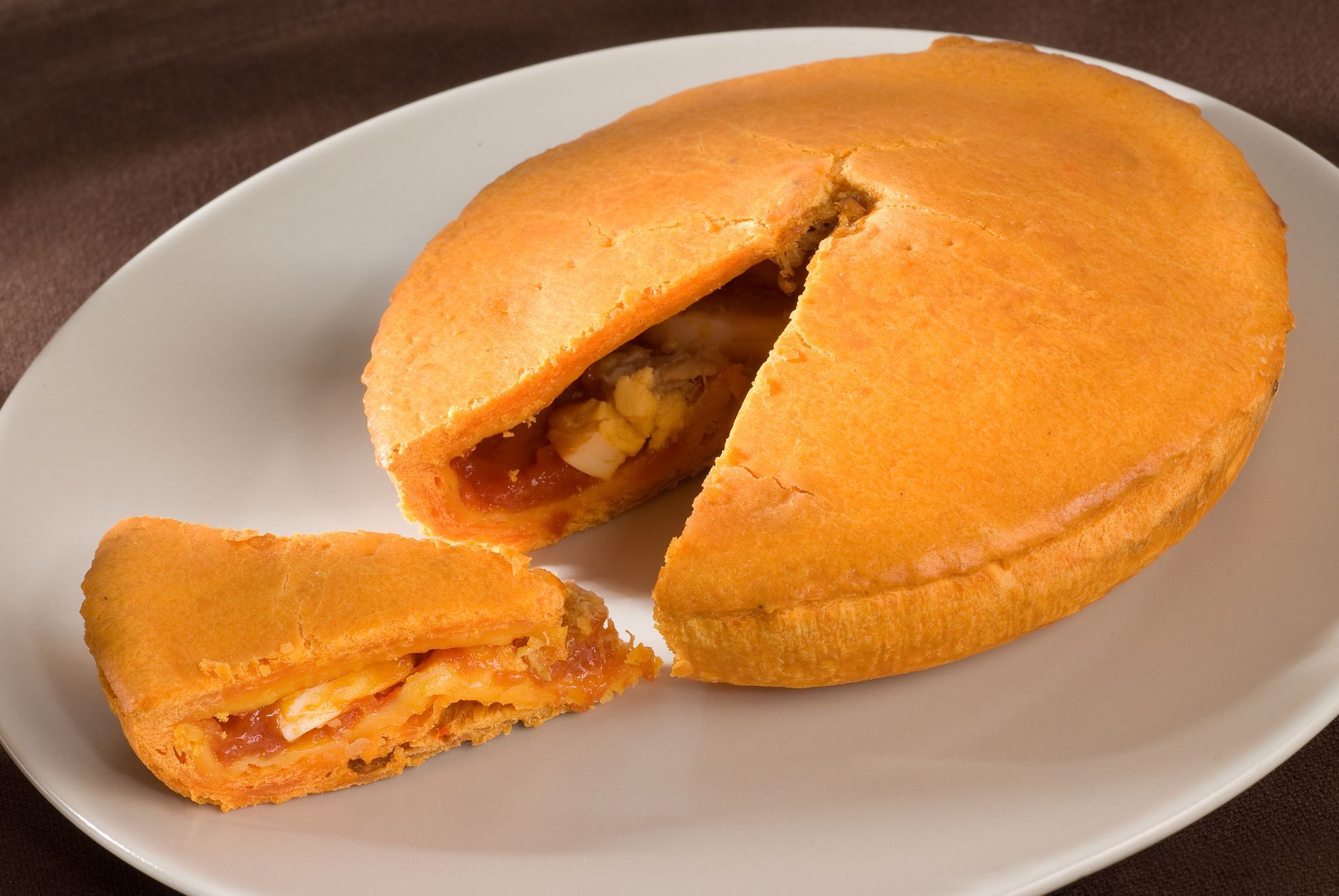 Un pastel con una rebanada sacada en un plato blanco