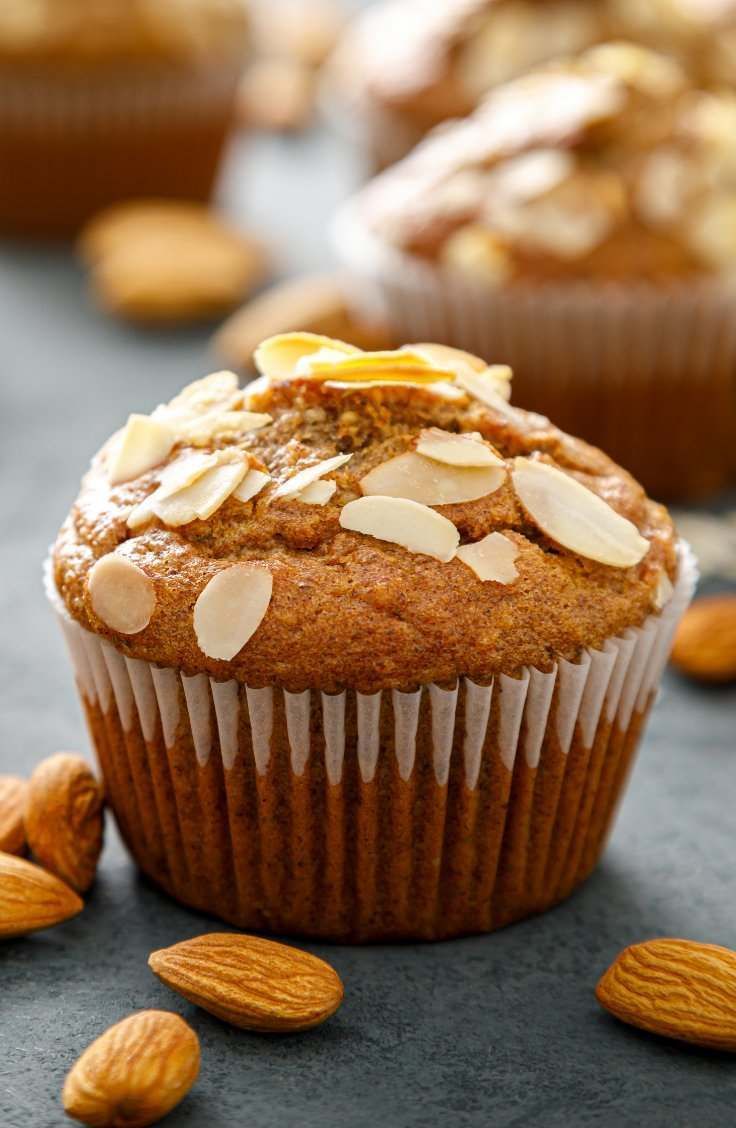 Un primer plano de un cupcake con almendras encima sobre una mesa.