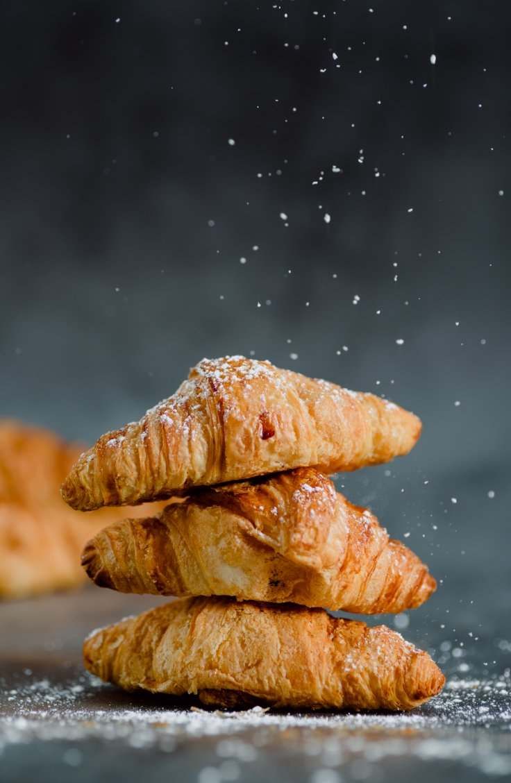 Tres croissants están apilados uno encima del otro sobre una mesa.