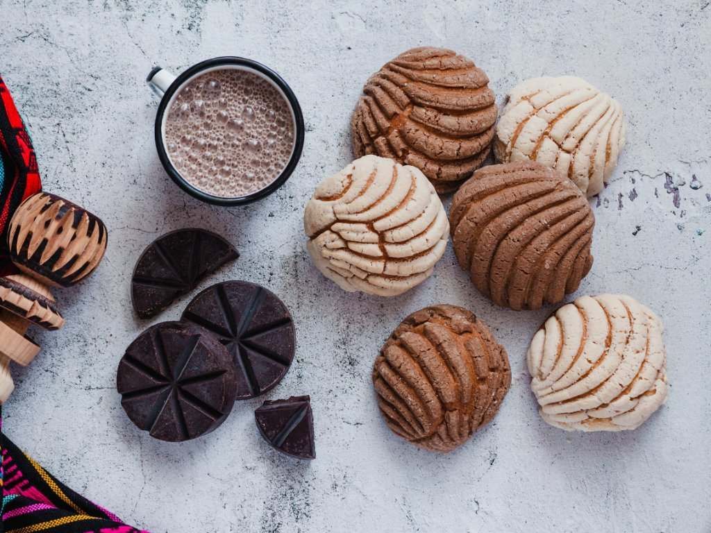 Hay muchos tipos diferentes de conchas y una taza de chocolate caliente.