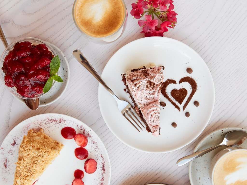 Una mesa cubierta con platos de postres y una taza de café.